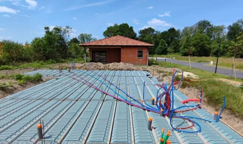 Dalle hourdis en attente de coulage avec réseaux de plomberie PER en place, sur un chantier de maison neuve
