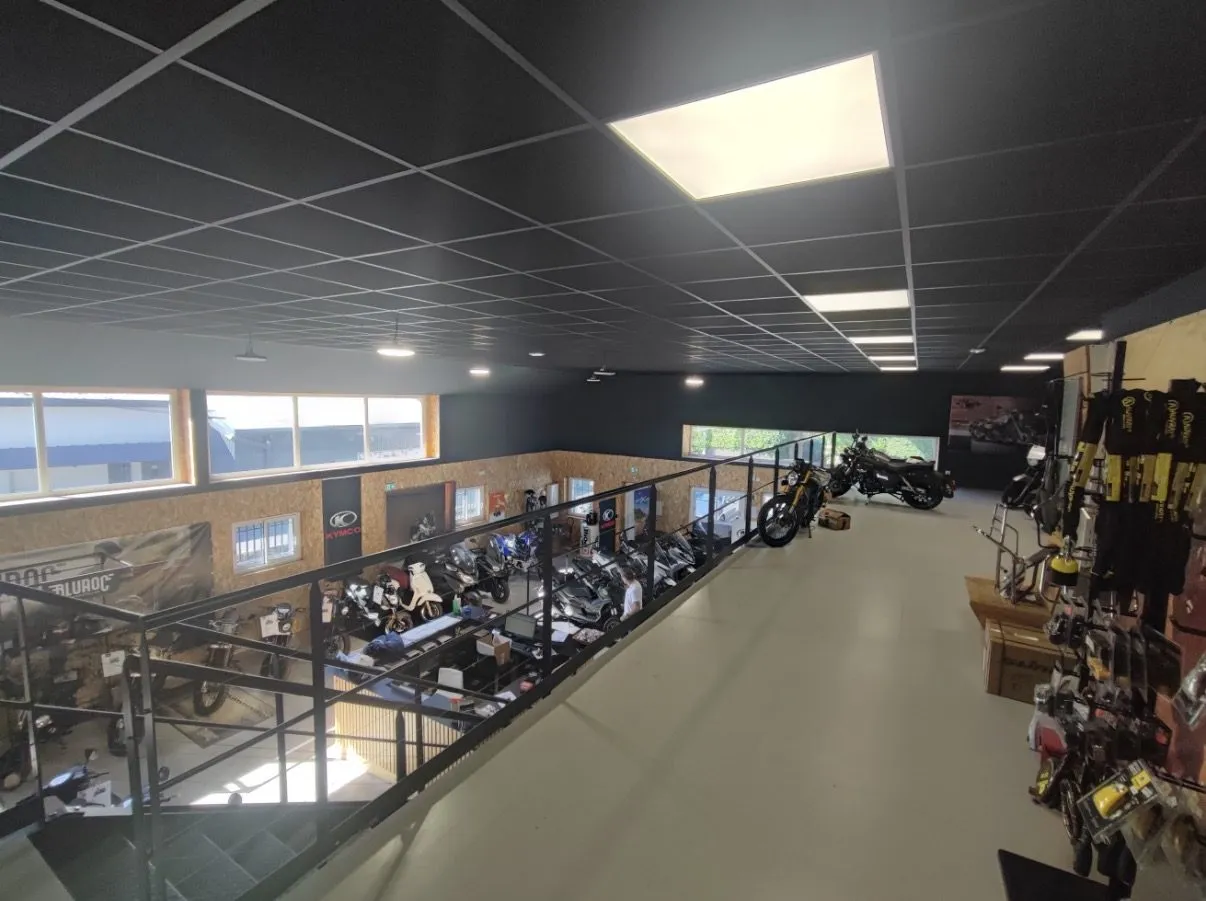 Étage de local professionnel livré : faux plafond en dalles acoustiques, dalles LED, habillage OSB et garde-corps noir
