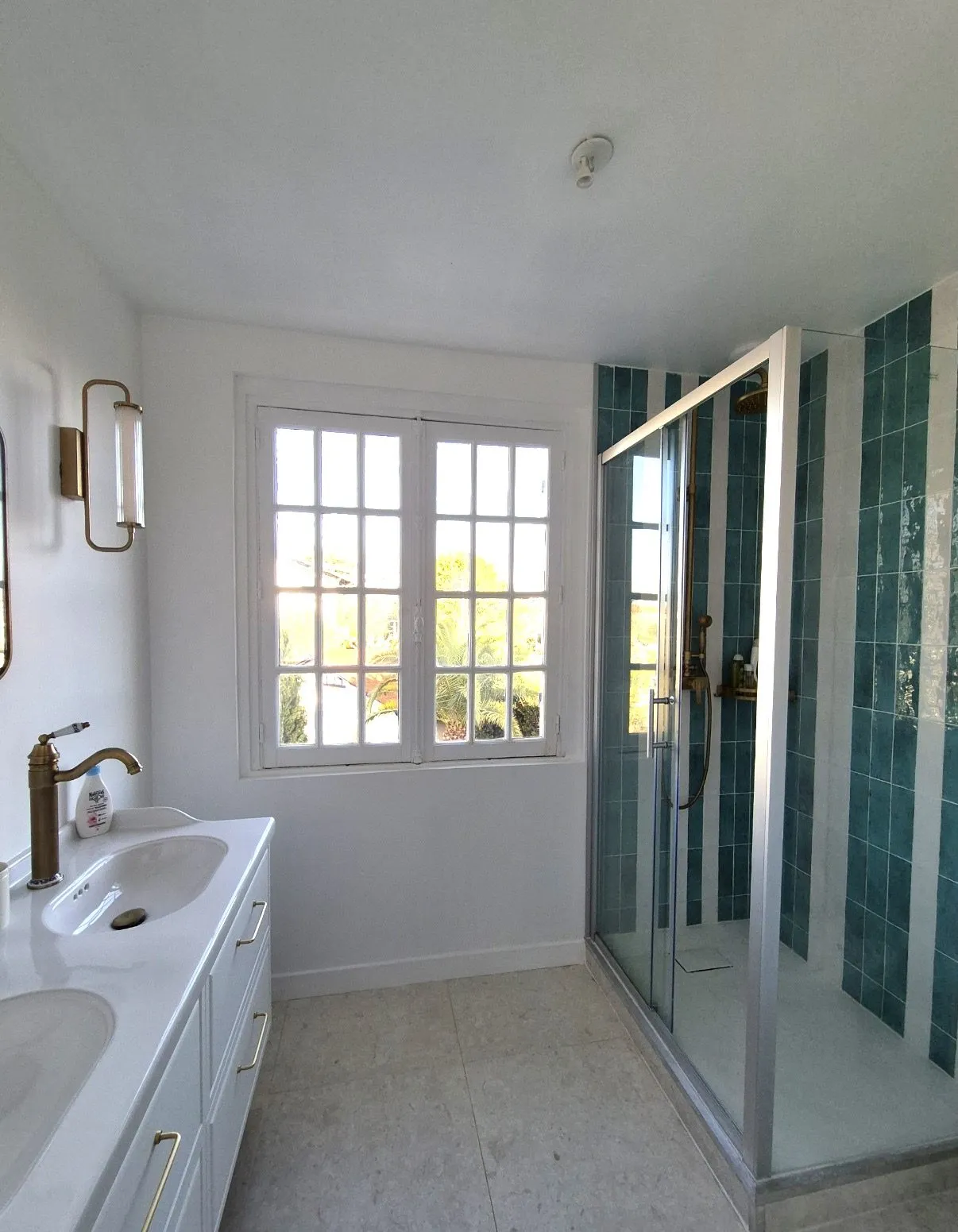 Salle de bains en zellige vert canard, double vasque sur meuble blanc et fenêtre à petits bois